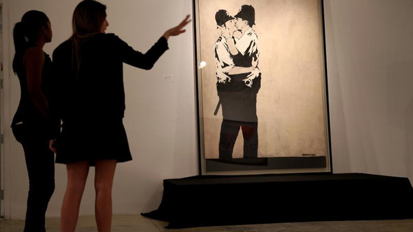 “قبلة بين رجلي شرطة” تعيد التقدير لفن الشوارع