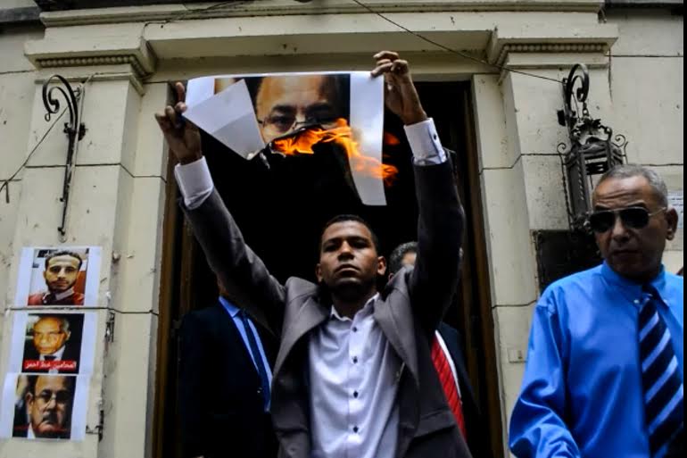 بالصور..محامون يشعلون النيران فى صورة وزير الداخلية