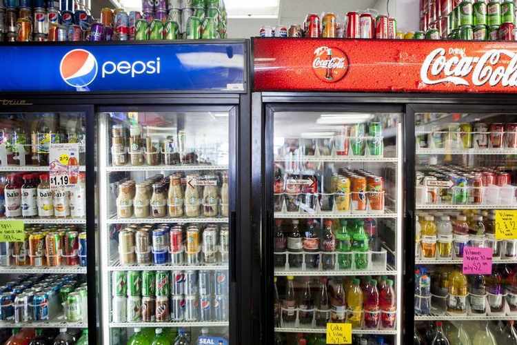 Cans of soda are displayed in a case at Kwik Stops Liquor in San Diego, California February 13, 2014. Sodas and most other sugar-sweetened drinks sold in California would be required to carry warning labels for obesity, diabetes and tooth decay under a bill introduced in Sacramento on Thursday and backed by several public health advocacy groups. REUTERS/Sam Hodgson (UNITED STATES - Tags: POLITICS FOOD HEALTH) - RTX18S2M