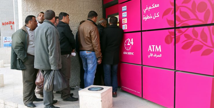 فلسطينيون يحتشدون أمام ماكينة صراف آلي