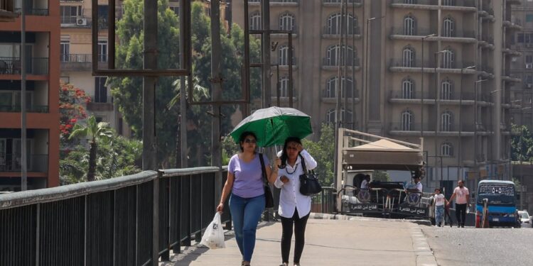 سيدتان على إحدى كباري القاهرة في مصر، بلومبرج.